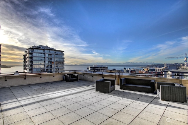 patio terrace at dusk featuring a water view