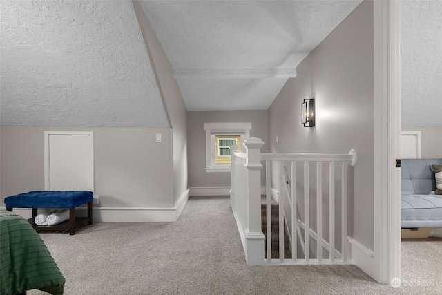 hallway with light carpet, a textured ceiling, and lofted ceiling