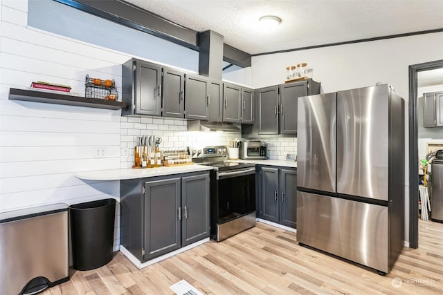 kitchen with decorative backsplash, light hardwood / wood-style floors, a textured ceiling, stainless steel appliances, and gray cabinets