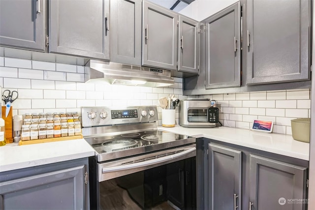 kitchen with backsplash, stainless steel electric range oven, and gray cabinetry