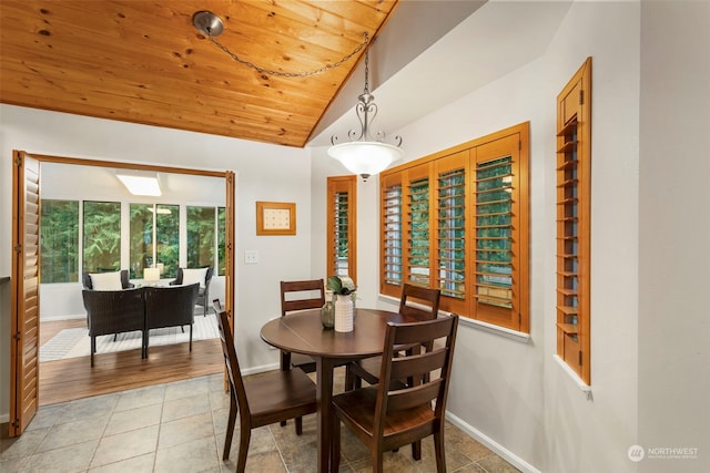 tiled dining space featuring vaulted ceiling and wood ceiling