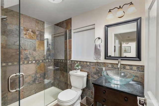 bathroom featuring vanity, toilet, tile walls, and walk in shower