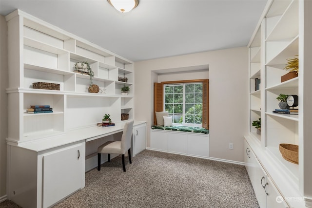 carpeted office space featuring built in desk