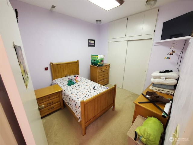 bedroom with light colored carpet and a closet