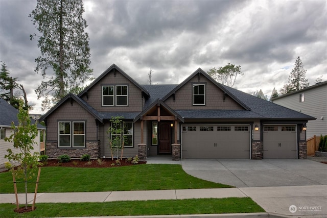 craftsman-style house featuring a garage and a front lawn