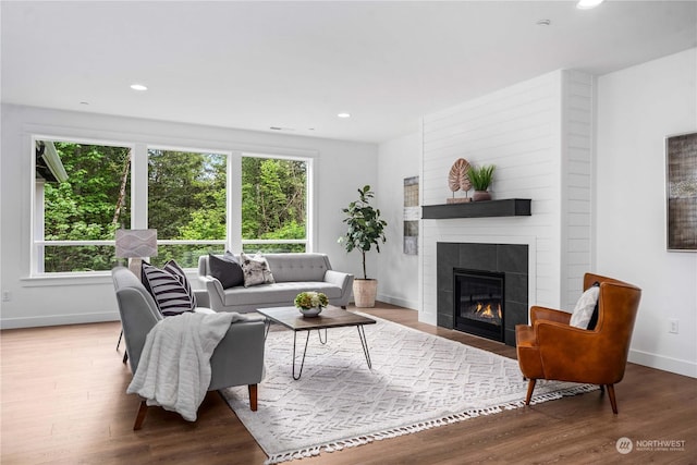 living room featuring a tile fireplace and hardwood / wood-style floors