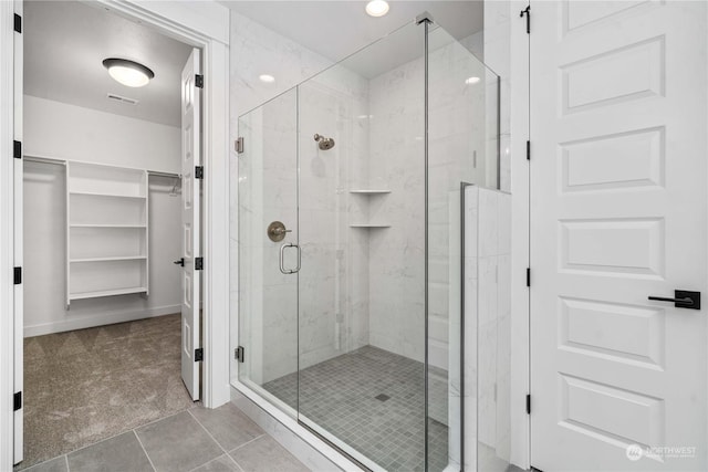 bathroom with tile patterned floors and a shower with door