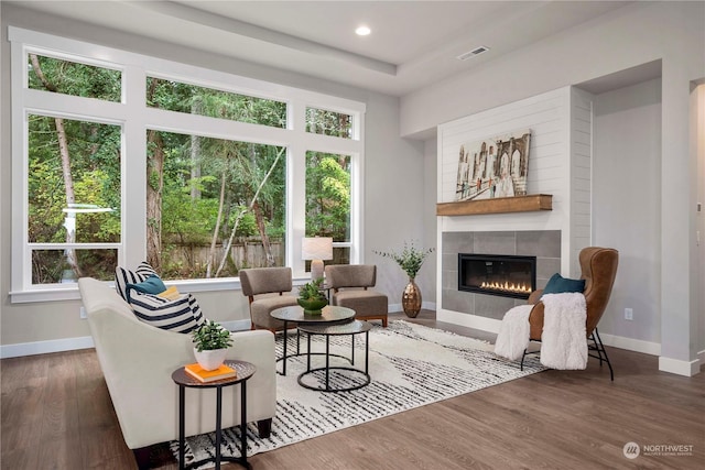 living room featuring dark hardwood / wood-style floors and a tiled fireplace