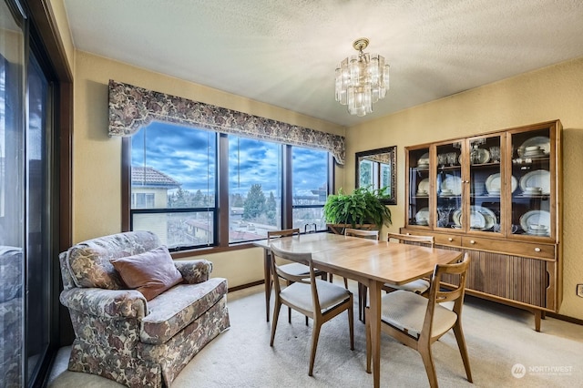 dining space featuring a textured ceiling, carpet floors, and a chandelier