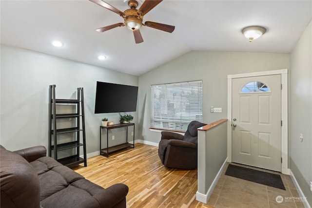 living room featuring ceiling fan, lofted ceiling, and light wood-type flooring