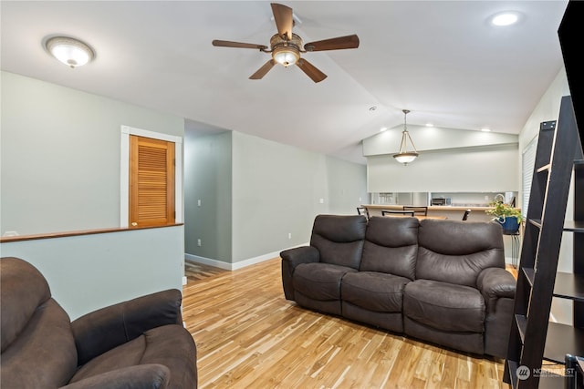 living room with ceiling fan, light hardwood / wood-style flooring, and lofted ceiling