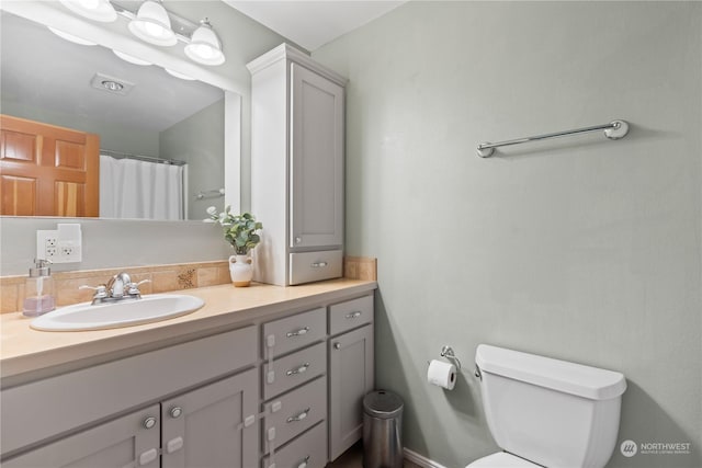 bathroom with a shower with curtain, vanity, and toilet