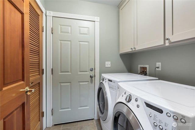 laundry area with separate washer and dryer, light tile patterned floors, and cabinets