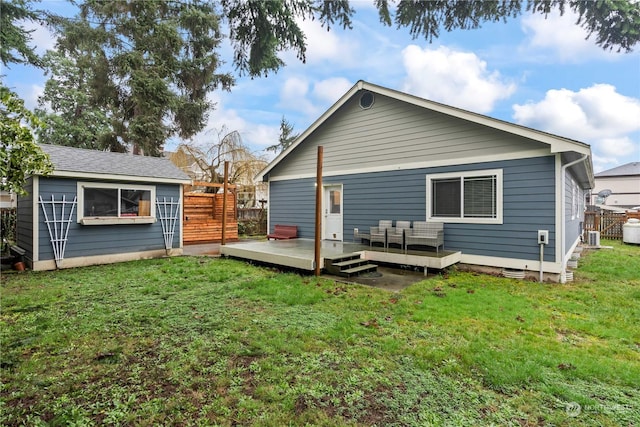 back of property featuring a lawn and a wooden deck