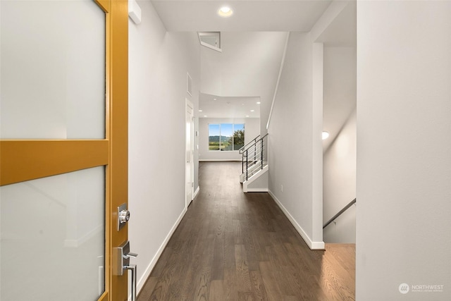 hallway featuring dark hardwood / wood-style floors and a towering ceiling