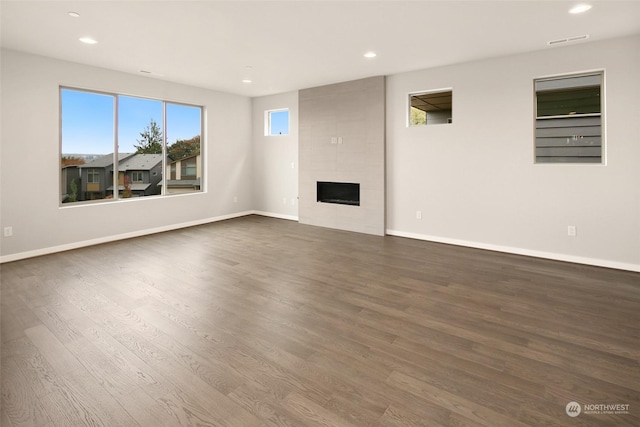 unfurnished living room featuring a fireplace and dark wood-type flooring