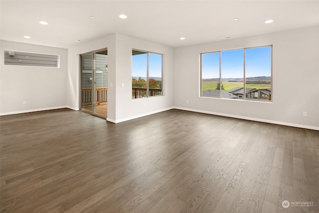 unfurnished room with dark hardwood / wood-style flooring