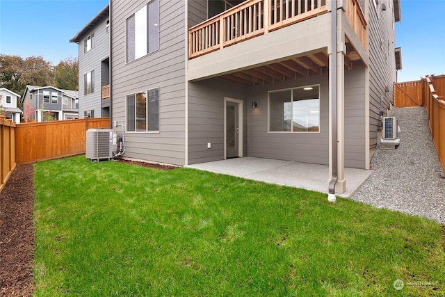 rear view of house featuring a lawn, a balcony, a patio, and central AC