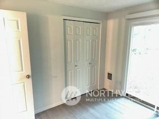 unfurnished bedroom featuring a closet and hardwood / wood-style flooring