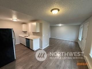 kitchen with white cabinetry, dark hardwood / wood-style flooring, black appliances, and a textured ceiling