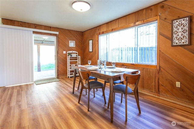 45143 Main St, Concrete, WA 98237 - dining room featuring light hardwood / wood-style floors, a healthy amount of sunlight, and wood walls
