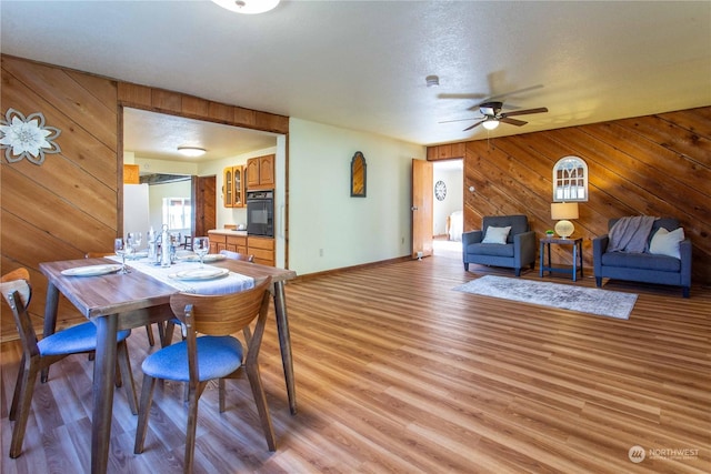 45143 Main St, Concrete, WA 98237 - dining space with wood walls, ceiling fan, a textured ceiling, and light wood-type flooring