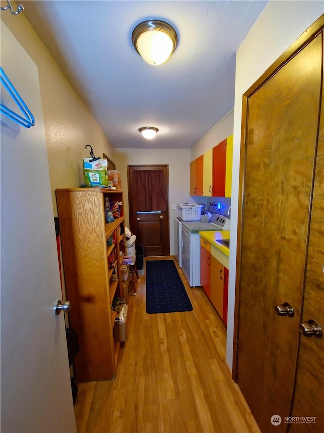 kitchen featuring washing machine and clothes dryer and light hardwood / wood-style flooring