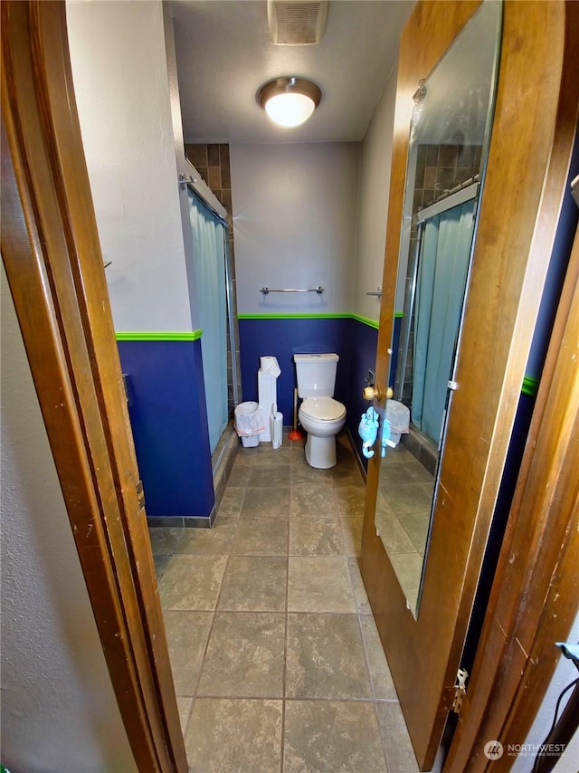 bathroom with toilet and a shower with shower door