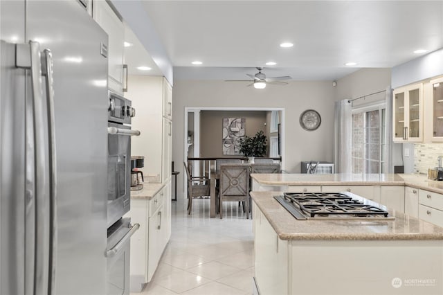 kitchen featuring white cabinets, decorative backsplash, a center island, and stainless steel appliances