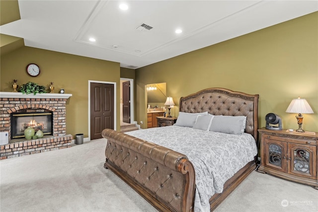 bedroom with light colored carpet, a brick fireplace, and a closet