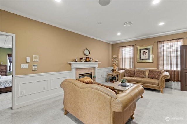 carpeted living room featuring a tile fireplace and crown molding