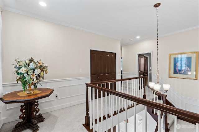 hall with light colored carpet and ornamental molding