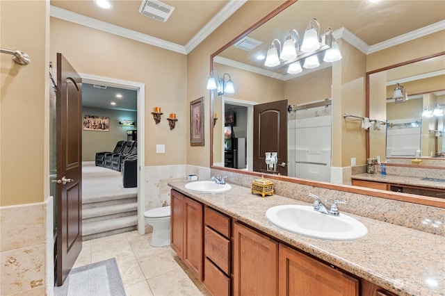 bathroom with tile patterned flooring, toilet, crown molding, and tile walls