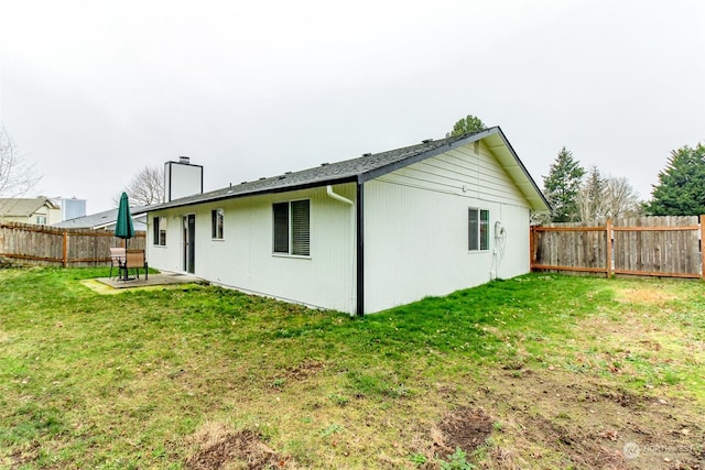 back of property with a patio area and a lawn