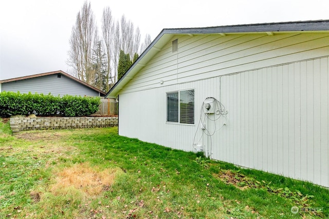 view of side of home with a lawn