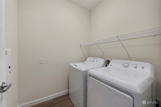 clothes washing area featuring washing machine and dryer and dark hardwood / wood-style floors