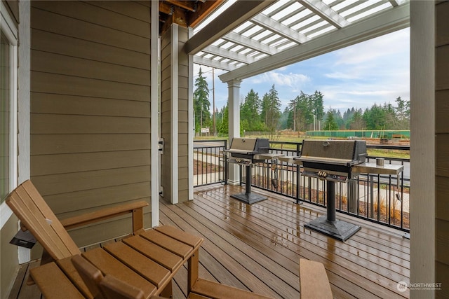 wooden terrace featuring a pergola and area for grilling