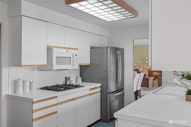 4144 94th Ave SE, Mercer Island, WA 98040 - kitchen featuring backsplash, white cabinetry, appliances with stainless steel finishes, and sink
