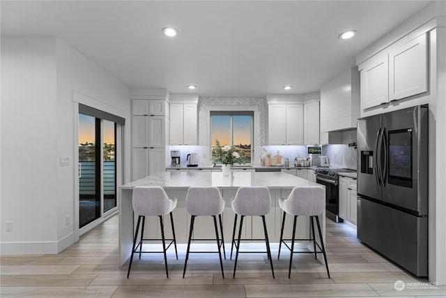 kitchen featuring premium range hood, a center island, white cabinets, and appliances with stainless steel finishes