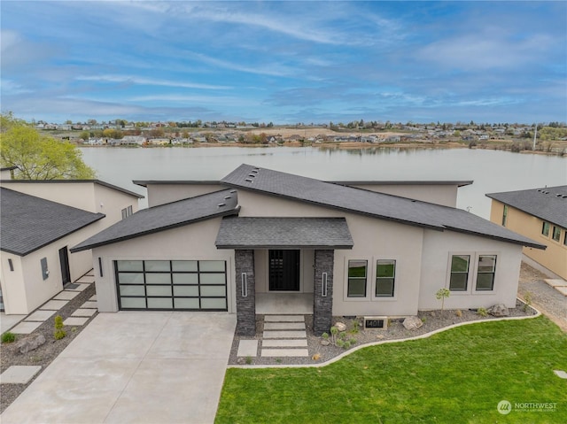 view of front of house featuring a water view, a front yard, and a garage