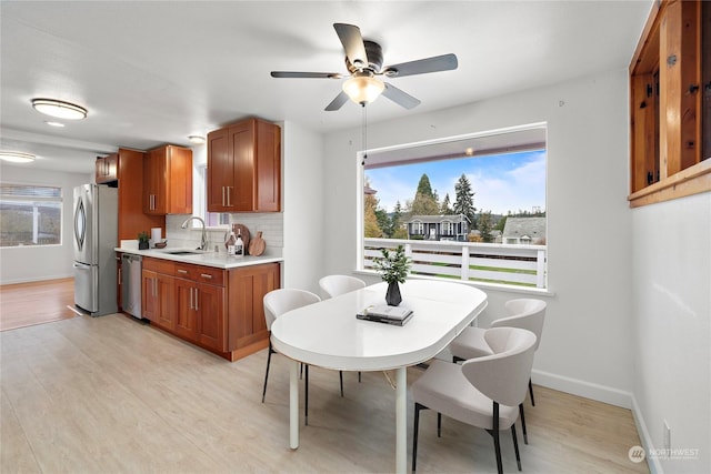 dining area with ceiling fan, sink, and light hardwood / wood-style floors