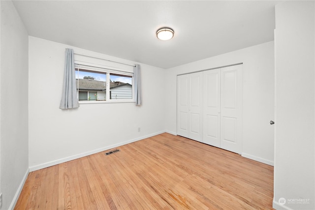 unfurnished bedroom with hardwood / wood-style floors and a closet