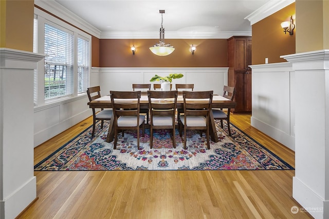 dining room with light hardwood / wood-style floors and crown molding