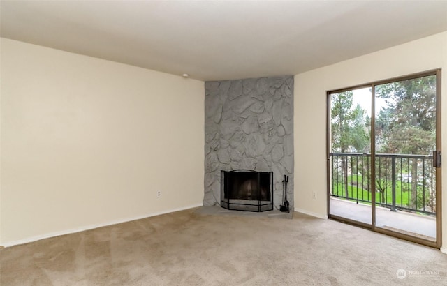 unfurnished living room with a stone fireplace and light colored carpet