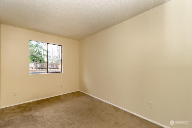 carpeted empty room featuring a textured ceiling