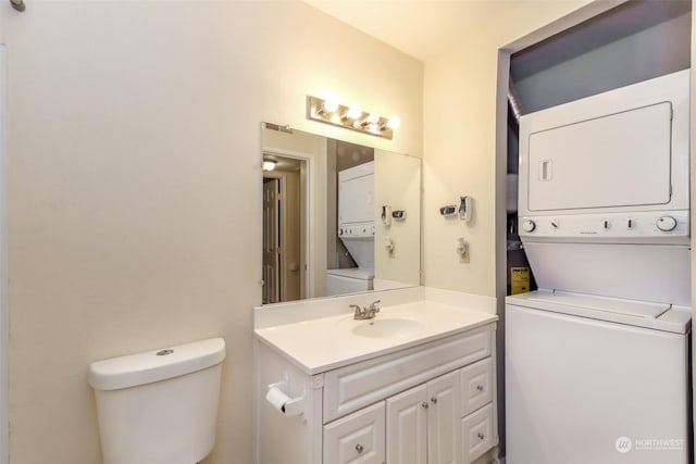 bathroom featuring vanity, toilet, and stacked washer / dryer