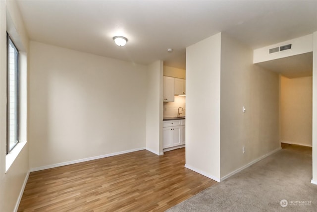 empty room featuring light wood-type flooring and sink