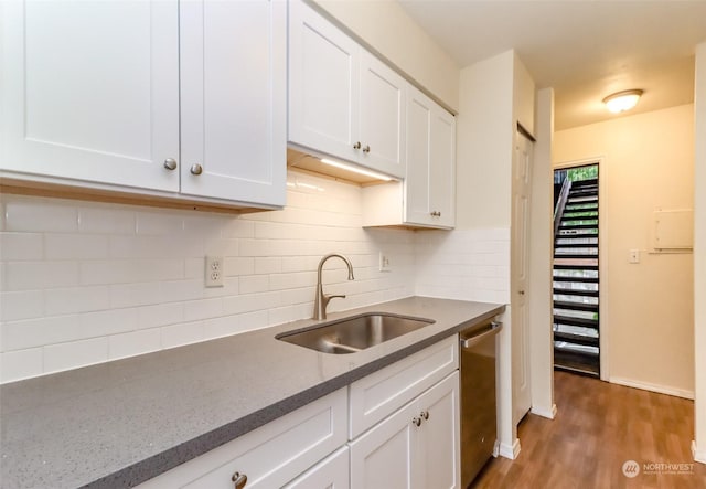 kitchen featuring tasteful backsplash, white cabinetry, sink, and stainless steel dishwasher