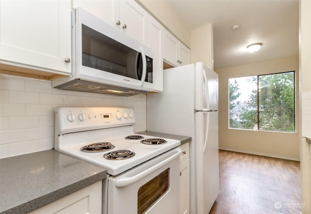 kitchen with decorative backsplash, white cabinetry, white appliances, and light hardwood / wood-style flooring