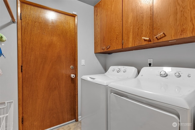 laundry area featuring separate washer and dryer and cabinets